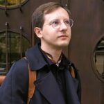 Maciej Wcisło, fundator i prezes IDN, w bramie modernistycznej kamienicy przy ul. Pędzichów 4 w Krakowie.